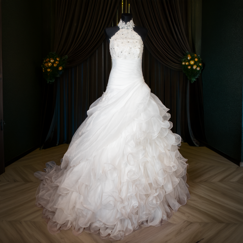Front view of a vintage Y2K halter neck wedding dress in bright white with lace bodice and ruffled organza skirt.