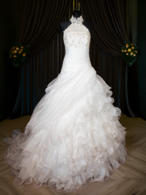Front view of a vintage Y2K halter neck wedding dress in bright white with lace bodice and ruffled organza skirt.